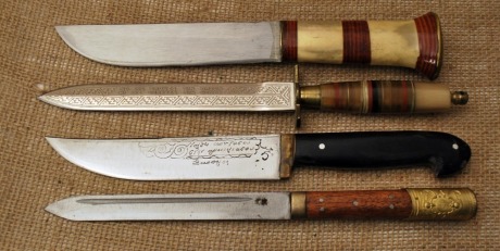 Four imported knives, pukko with bone and stacked leather washers, dagger with etched blade and brass fitting, Hunter with etched blade and horn handle in a foreign language I do not know, and Oriental motif straight blade with wood handles and brass pomm